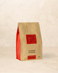 Bag of Classic Plunger coffee with dark chocolate, cinnamon, and brown sugar notes.