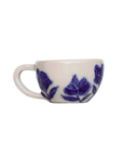 White ceramic cup with blue floral patterns on a white background