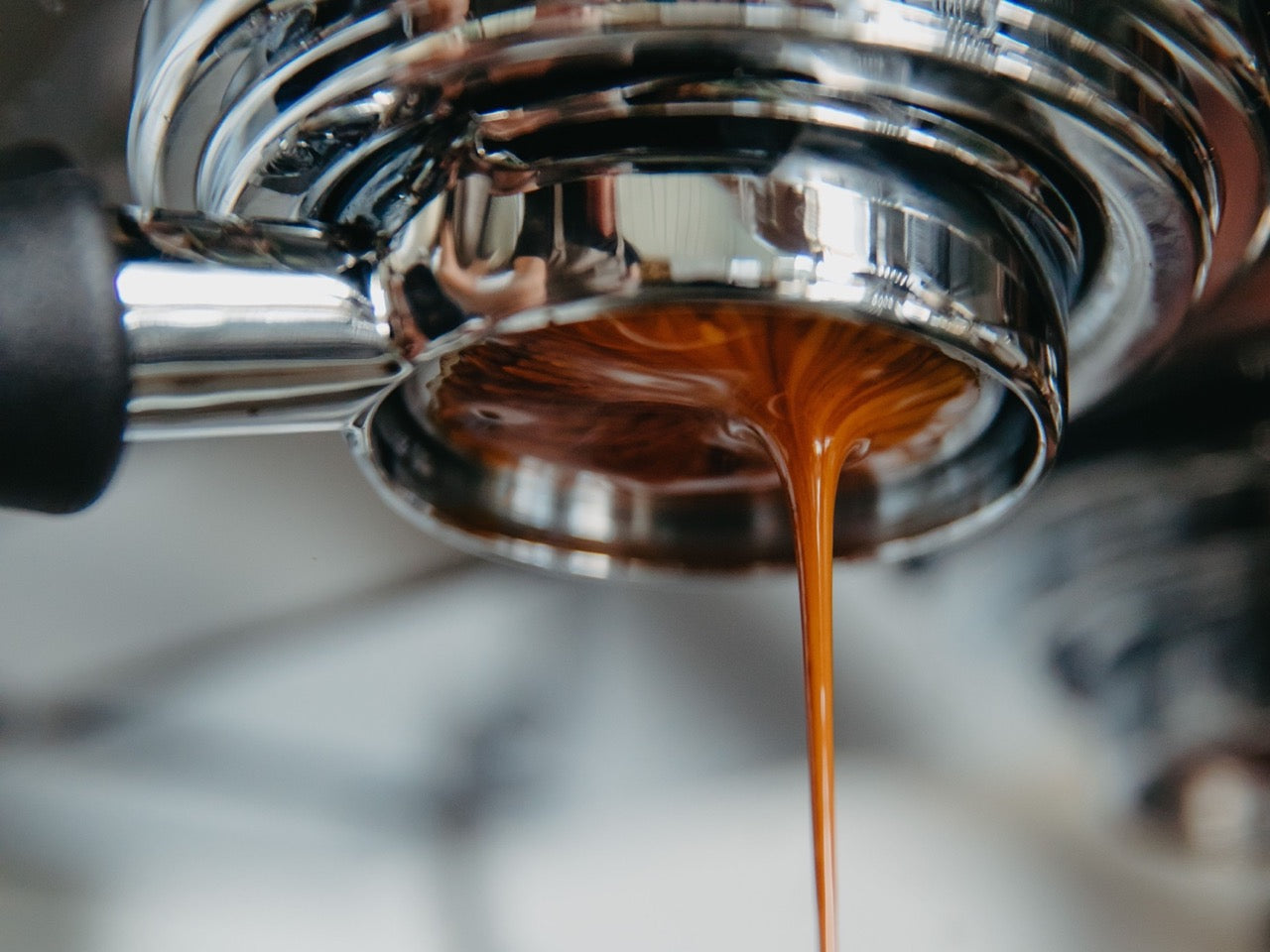 Espresso shot pouring from a group handle, showing golden crema