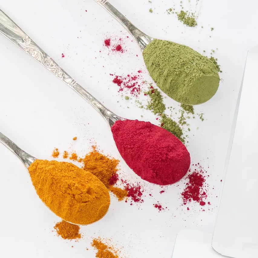 Turmeric, Matcha and turmeric latte mixes on spoons with white background