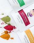 Beetroot, turmeric, and matcha powders on teaspoons with packaging