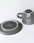 ACME grey ceramic cup and saucer on a white background