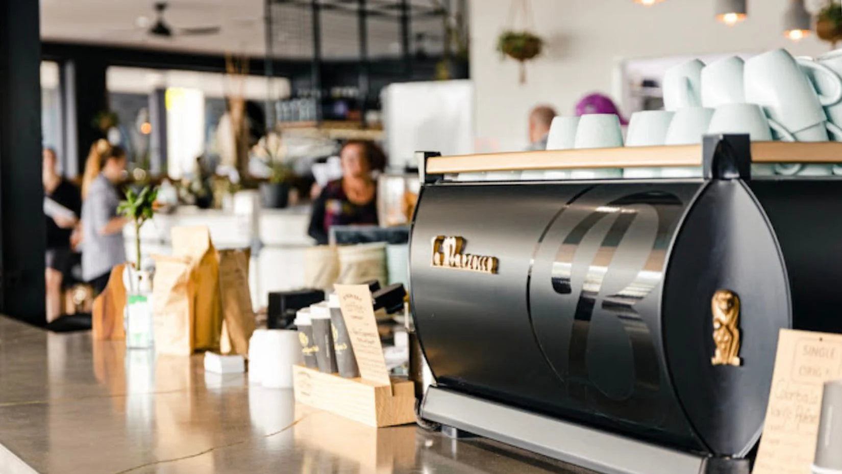 La Marzocco coffee machine in a modern cafe setting with people in the background