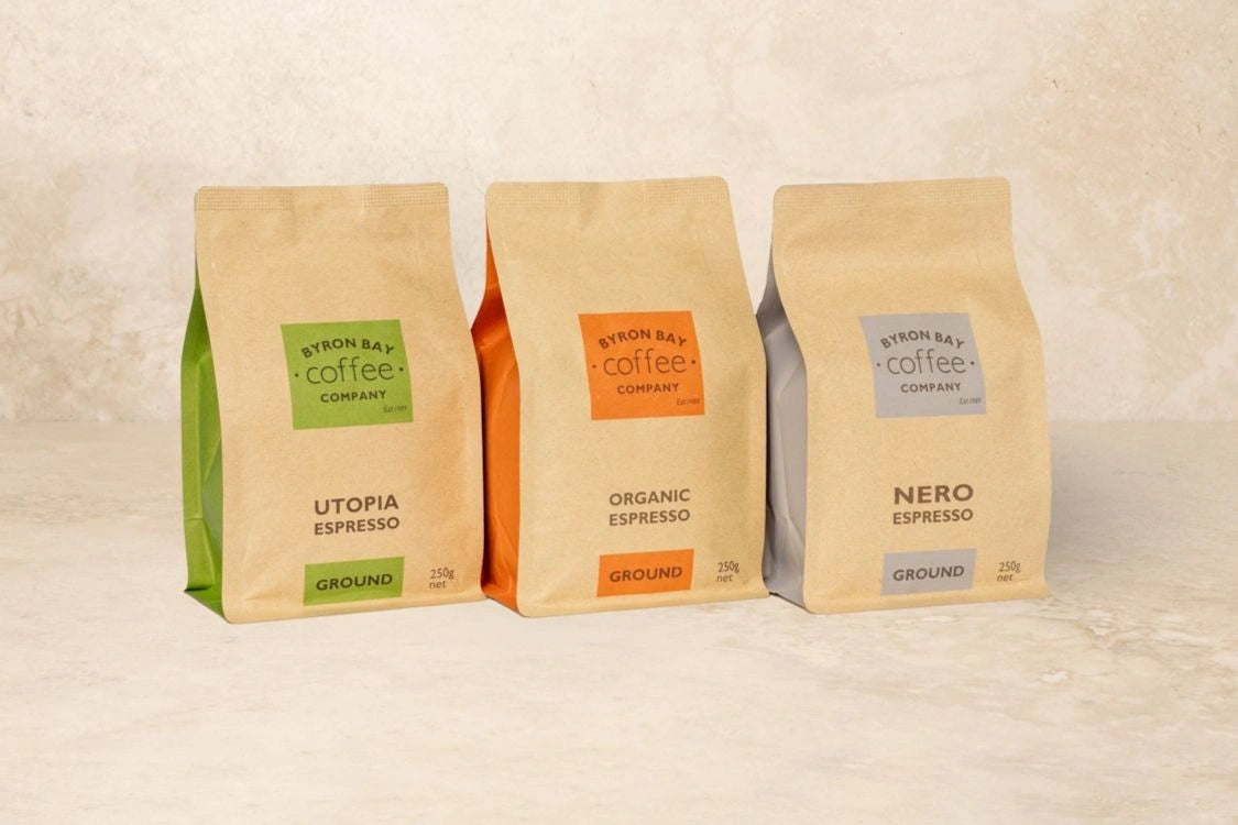 Three coffee bags from Byron Bay Coffee Company on a beige background