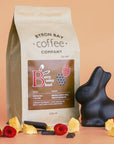 Byron Bay Coffee Company coffee package with chocolate bunny and berries on a peach background