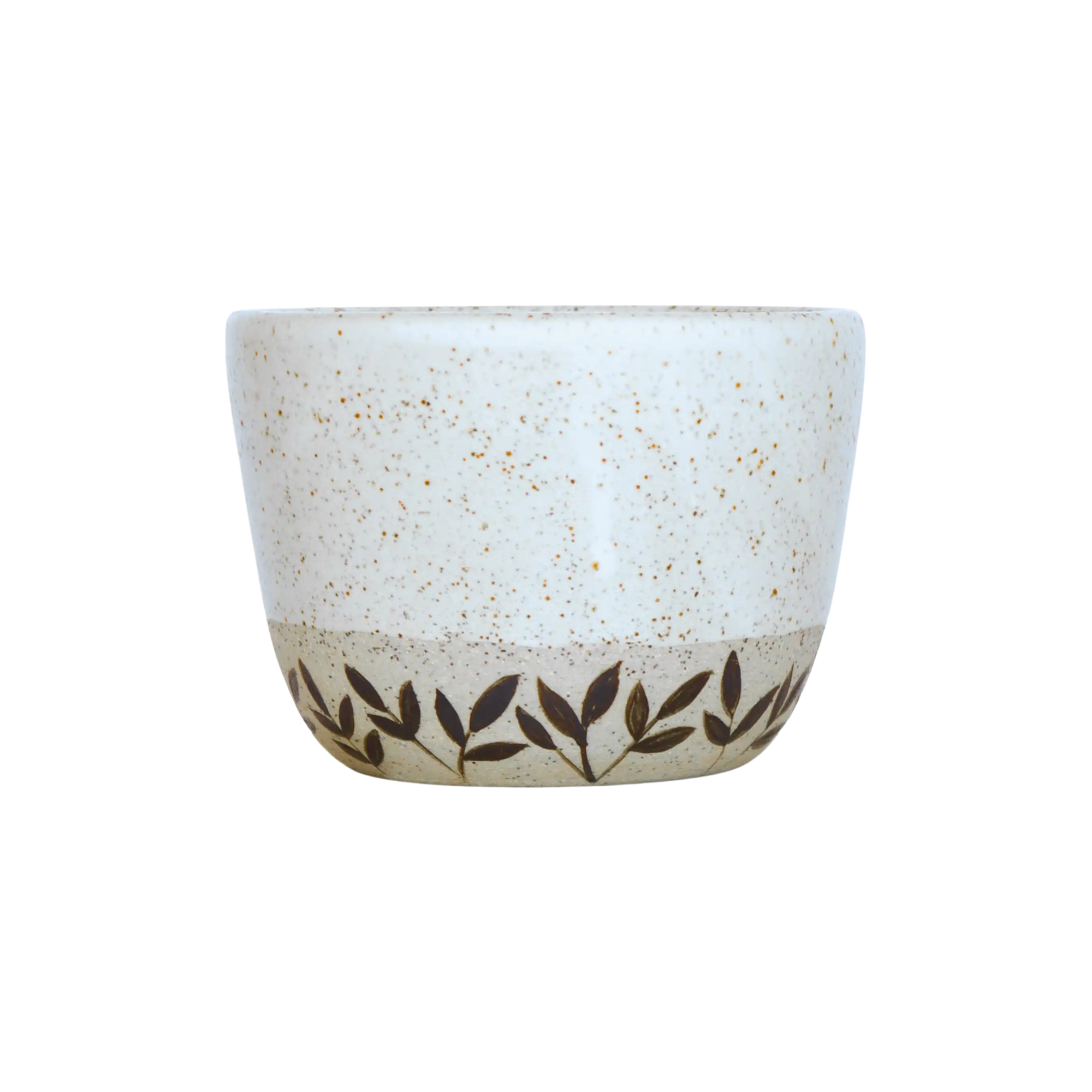 Ceramic coffee cup with speckled design and leaf pattern on a white background