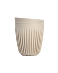 Beige textured ceramic cup with lid on a white background