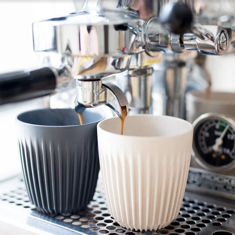 Espresso coffee shots being poured into reusable Huskee cups