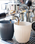 Espresso coffee shots being poured into reusable Huskee cups