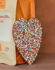 Coffee bag from Byron Bay Coffee Company with a colorful heart-shaped object on a brown background