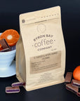 Bag of Colombian single origin coffee for filter next to tangerines and little blocks on Turkish delight
