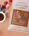 Byron Bay Coffee Company Berry Bunny Blend package with a cup of coffee and berries on a peach background