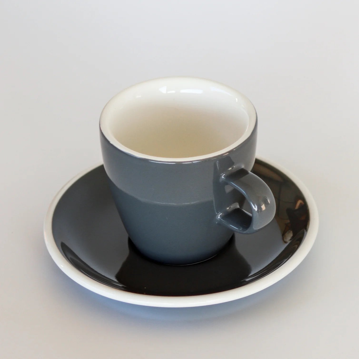 Grey coffee cup and saucer on a white background